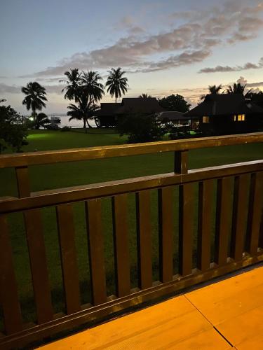 a wooden fence with a view of a golf course at Pension Reva Teahupoo in Toanoano