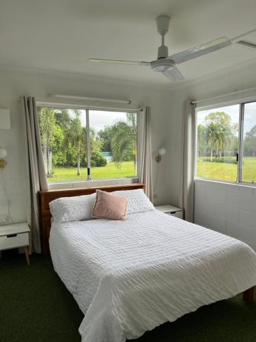 a bedroom with a white bed with a window at Coral Reef Resort in Cairns