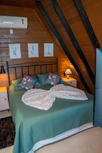 a bedroom with a bed with green sheets and pillows at Caminhos da Esmeralda in Urubici