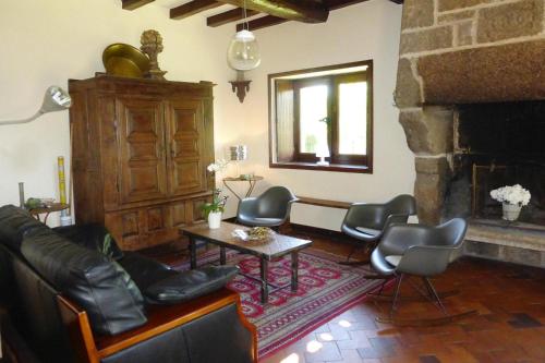 a living room with leather chairs and a fireplace at Mill in Brittany by River Aulne with Kayaks in Landeleau