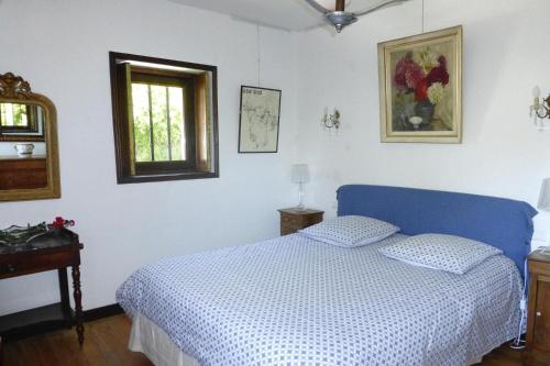 a bedroom with a blue bed and a window at Mill in Brittany by River Aulne with Kayaks in Landeleau