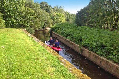 two people are riding in a canoe down a river at Mill in Brittany by River Aulne with Kayaks in Landeleau