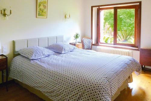 a bedroom with a large bed with a window at Mill in Brittany by River Aulne with Kayaks in Landeleau