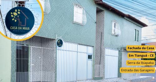 ein blaues Gebäude mit einem Tor und einem Schild in der Unterkunft Casa da Maia Hostel in Tianguá