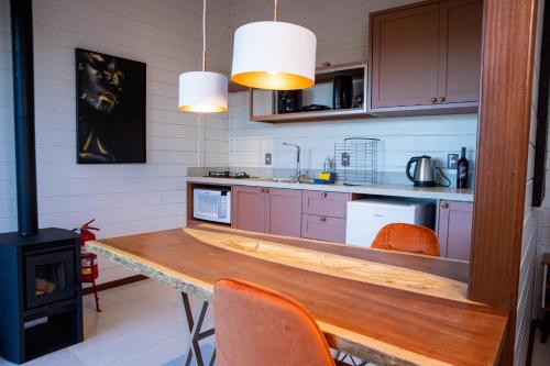 una cocina con una mesa de madera y una estufa en Caminhos da Esmeralda, en Urubici