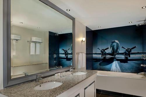 a bathroom with two sinks and a large mirror at Sheraton Heathrow Hotel in Hillingdon