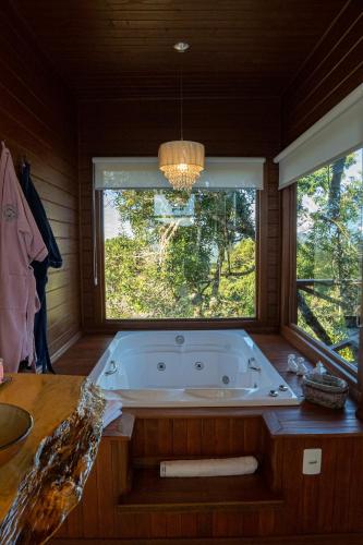 a large bath tub in a room with a window at Caminhos da Esmeralda in Urubici
