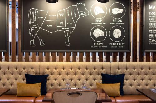 a drawing of a cow on the wall of a restaurant at Sheraton Heathrow Hotel in Hillingdon