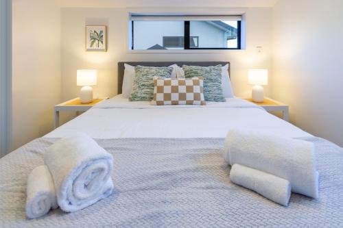 a bedroom with a large bed with towels on it at Charming Downtown hideaway 1 bed 1 bath in Christchurch
