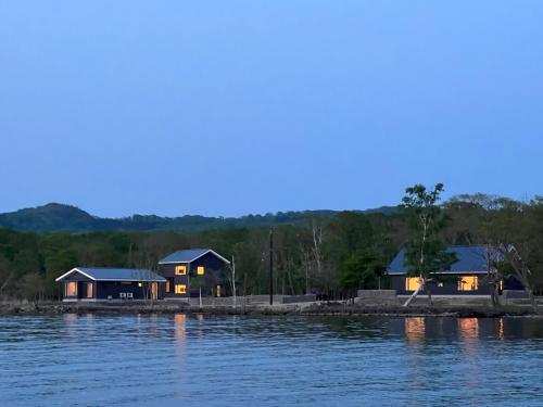 a couple of houses on the shore of a lake at Wakkanupuri Resorts in Teshikaga