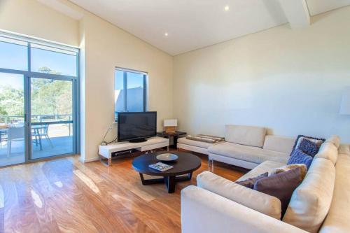 una sala de estar con un sofá y una mesa en Eagle Escape I Private Properties, en Dunsborough
