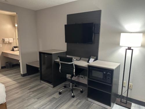 a room with a desk with a computer and a lamp at La Quinta Inn by Wyndham Omaha Southwest in Omaha