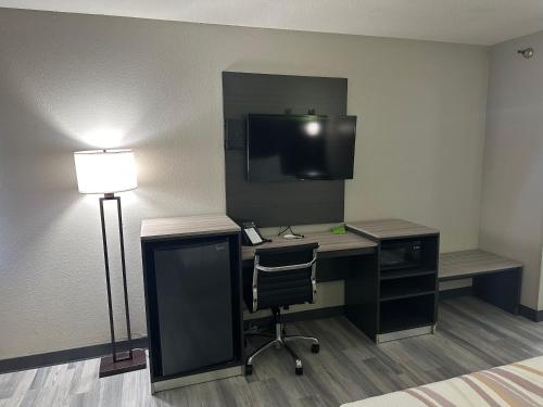 a room with a desk with a computer and a tv at La Quinta Inn by Wyndham Omaha Southwest in Omaha