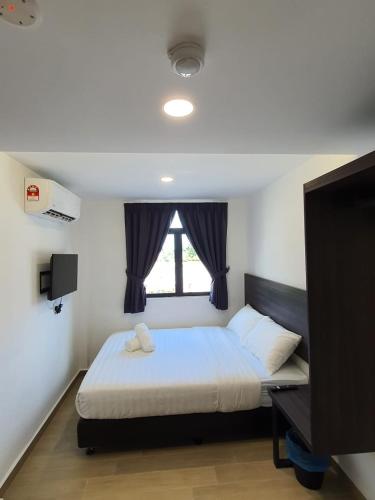 a small bedroom with a bed and a window at E Hotel in Kulim