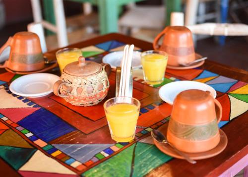 uma mesa de madeira com pratos e copos de sumo de laranja em La Posada de Tafi em Tafí del Valle