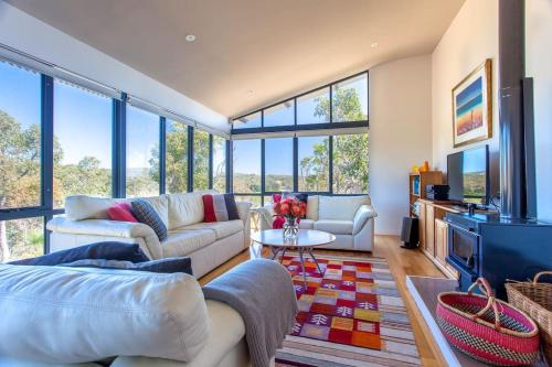 a living room with couches and a tv and windows at Matilda I Private Properties in Dunsborough