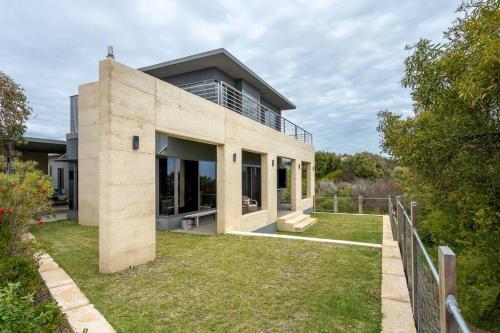 a large concrete house with a yard at Oceanic I Private Properties in Dawesville