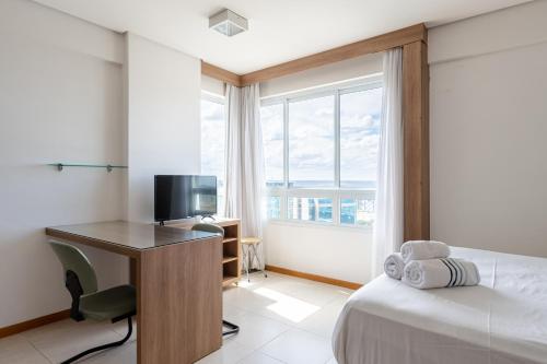 a bedroom with a bed and a desk with a television at BSB STAY Premium Flats Particulares - Saint Moritz in Brasilia