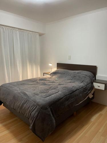 ein Schlafzimmer mit einem großen Bett und einem großen Fenster in der Unterkunft Departamento Irigoyen in Trelew