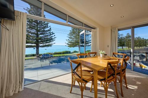 een eetkamer met een tafel en stoelen en een groot raam bij Kaikoura Waterfront Apartments in Kaikoura