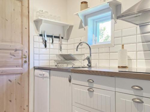 uma cozinha branca com um lavatório e uma janela em Holiday home GRÄNNA VI em Gränna
