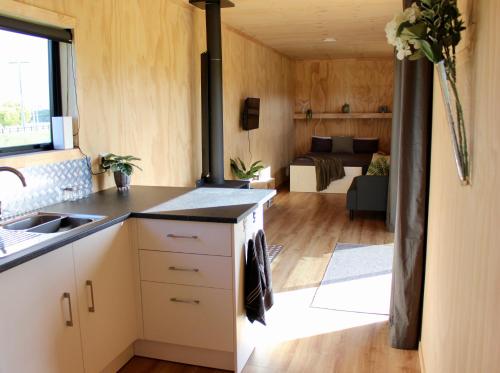 a kitchen and living room in a tiny house at Luxury Container Cabin in Masterton
