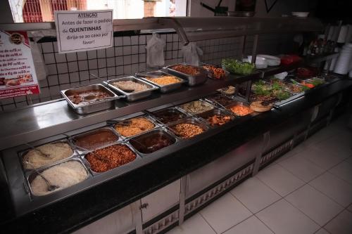 a buffet line with many different types of food at HOTEL, RESTAURANTE E LANCHONETE PRIME in Valença
