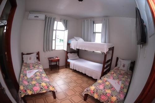 a small room with two bunk beds and a television at HOTEL, RESTAURANTE E LANCHONETE PRIME in Valença