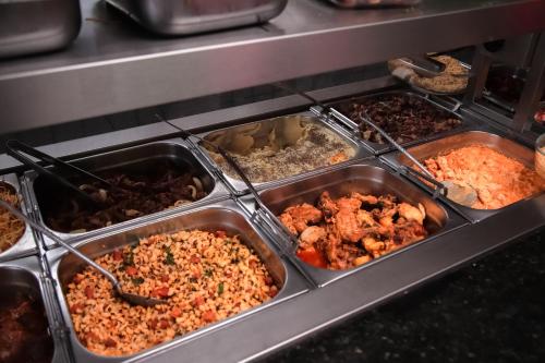 a buffet filled with different types of food in trays at HOTEL, RESTAURANTE E LANCHONETE PRIME in Valença