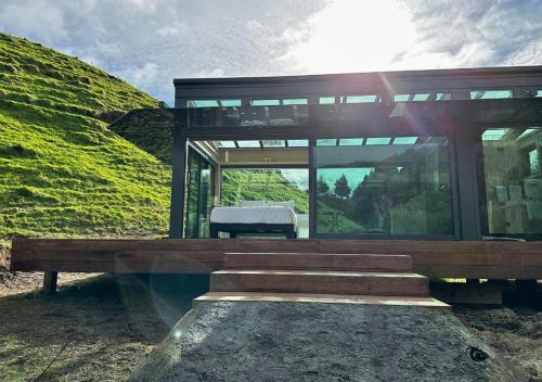 a house on top of a hill with a bench at Pāmu PurePod in Rotorua