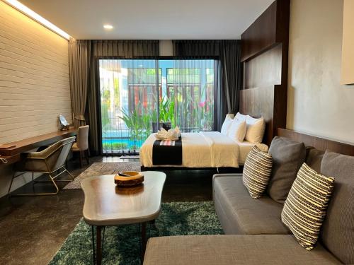 a hotel room with a bed and a couch at NAI YA Hotel -SHA Extra Plus in Chiang Rai