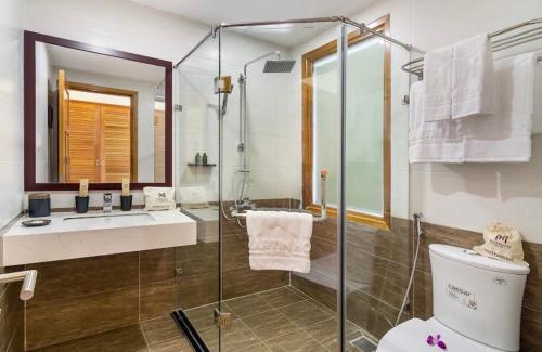 een badkamer met een douche, een toilet en een wastafel bij Martin Ho Danang hotel & apartment in Da Nang