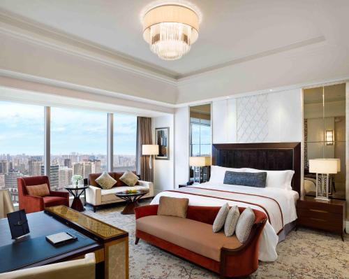 a bedroom with a large bed and a living room at The St. Regis Chengdu in Chengdu