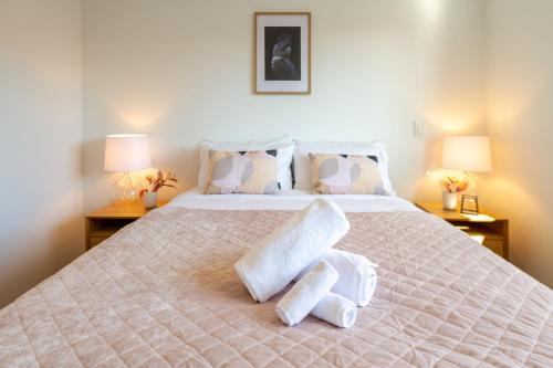 a bedroom with a large bed with towels on it at Vibrant Central Christchurch Pad 2 bed 1 bath in Christchurch