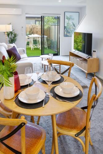 a living room with a wooden table and chairs at Vibrant Central Christchurch Pad 2 bed 1 bath in Christchurch