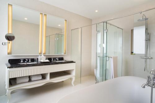 a white bathroom with a sink and a shower at Four Points by Sheraton Bandung in Bandung