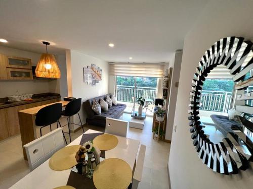 ein Wohnzimmer mit Tisch und ein Esszimmer in der Unterkunft Espectacular vista cerca a cable plaza con Piscina in Manizales