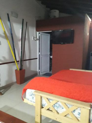 1 dormitorio con 1 cama con colcha roja en Monoambiente hospital en Santa Teresita