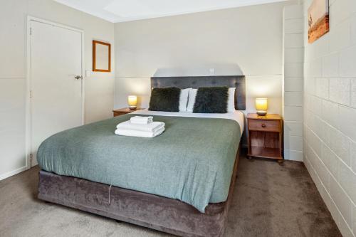 a bedroom with a large bed with two night stands at Camellia with WiFi - Paihia Unit in Paihia