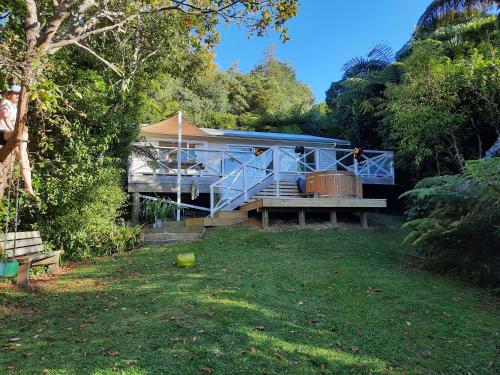 a house in the middle of a yard at Mahakipawa Waterfront Hideaway - Belvue Bay Home in Linkwater
