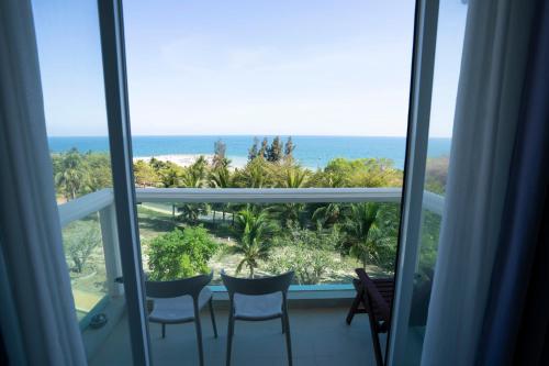 a room with a view of the ocean from a balcony at Jack's Home - Ocean Vista Condotel Sealink Mui Ne in Mui Ne