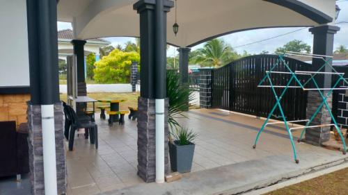 a covered patio with a table and chairs at Rosspine Homestay in Jitra