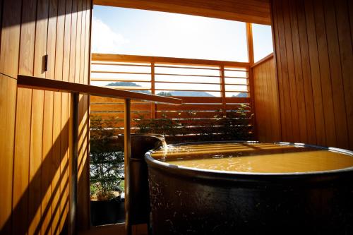 a hot tub in a room with a large window at Nakanobo Zuien (Adult Only) in Kobe