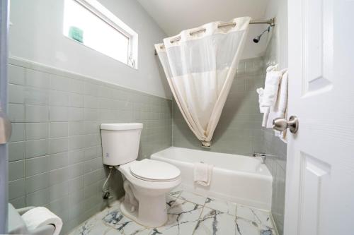 a bathroom with a toilet and a bath tub at OYO Hotel Ocala, FL I-75 in Ocala