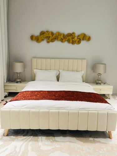 a bedroom with a large white bed with two lamps at ِALMABEET Resort in Sinādil