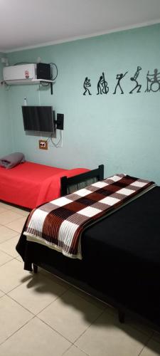 a room with two beds and a tv on the wall at APART PIEDRAS,Cochera,Desayuno seco 3 5 3 5 6 3 4 5 1 4 in Villa María
