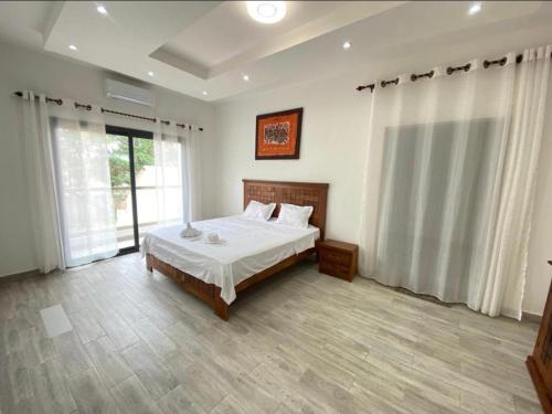 1 dormitorio con cama y ventana grande en pieds dans l'eau nianing, en Nianing