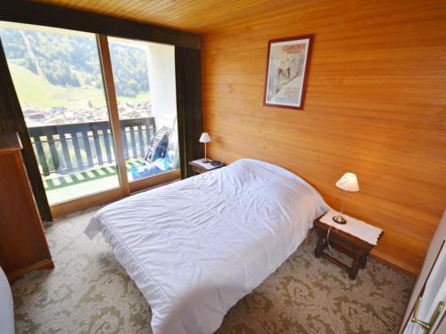 une chambre avec un lit et une grande fenêtre dans l'établissement Appartement T3 pour 6 pers. avec piscine, parking, et balcon - Morzine - FR-1-684-48, à Morzine