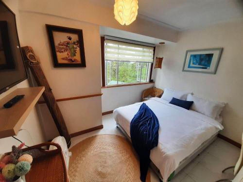 ein kleines Schlafzimmer mit einem Bett und einem Fenster in der Unterkunft Relaxing / Minimalist homestay - 1 Bed & Bath in Camp John Hay