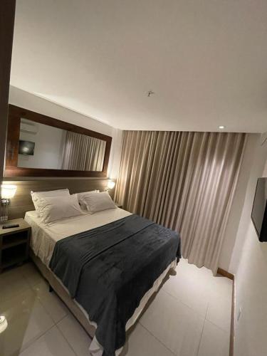 a bedroom with a large bed and a large window at Flat Rio Centro, 1km do Rio centro 3km da Jeunesse Arena Parque Olímpico em frente ao Projac e a poucos minutos da Praia da Barra in Rio de Janeiro